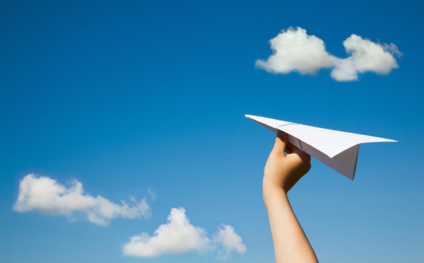 Ребенок запускает бумажный самолетик