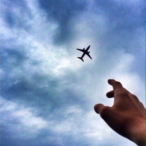 Рука и самолет в небе