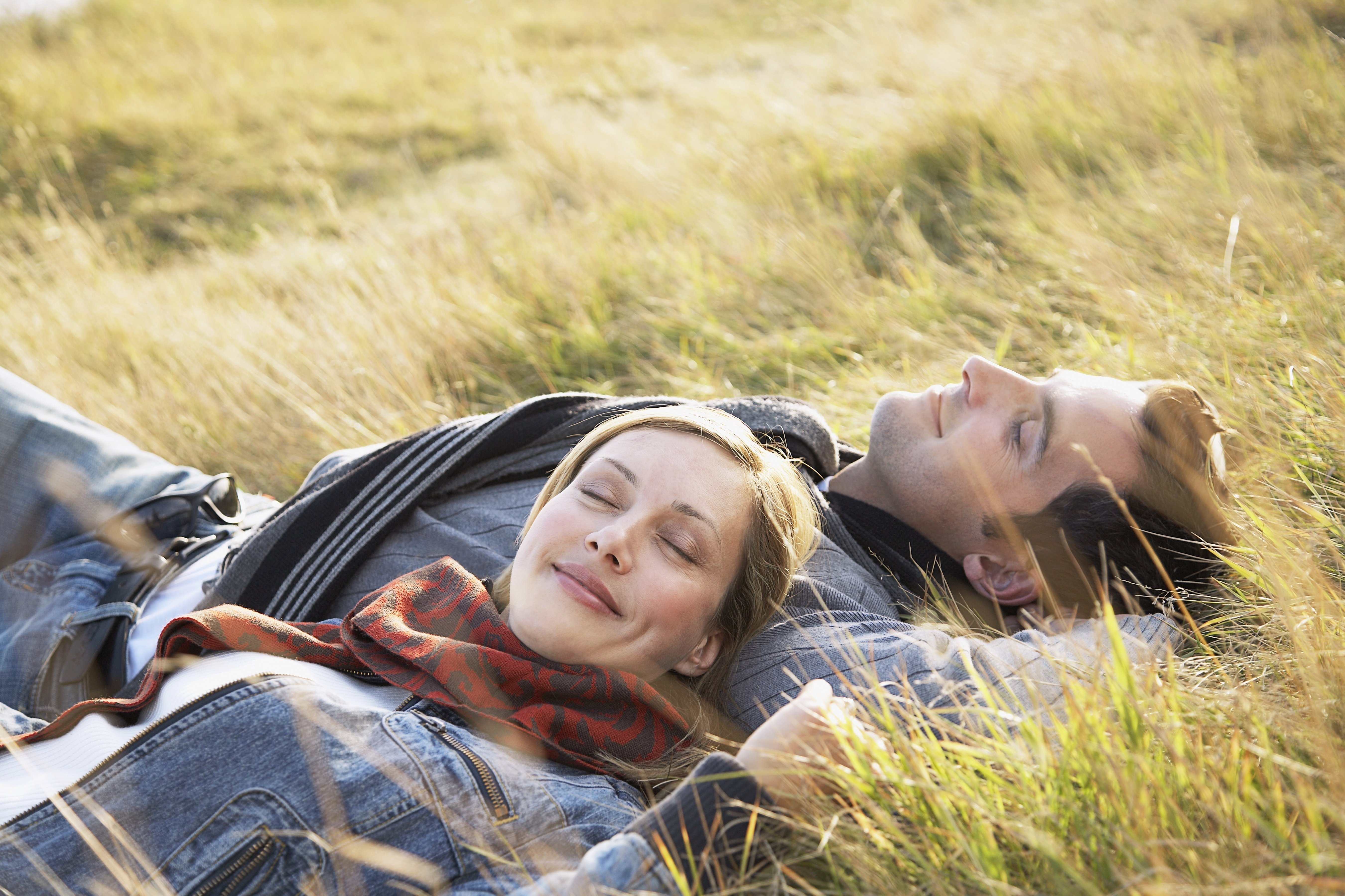Все таки жизнь прекрасна. Влюбленные лежат на траве. Мужчина и женщина на природе. Мужчина и женщина лежат на траве. Счастливые влюбленные.