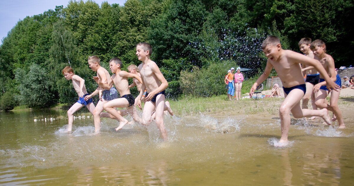 Дети купаются в озере. Купание детей в лагере. Купание летом. Школьники на речке.