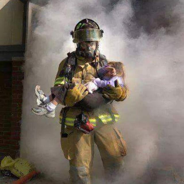 Выносит из пожара. Пожарный с ребенком на руках. Для детей. Пожарные. Пожарный спасает ребенка. Пожарник выносит ребенка из огня.