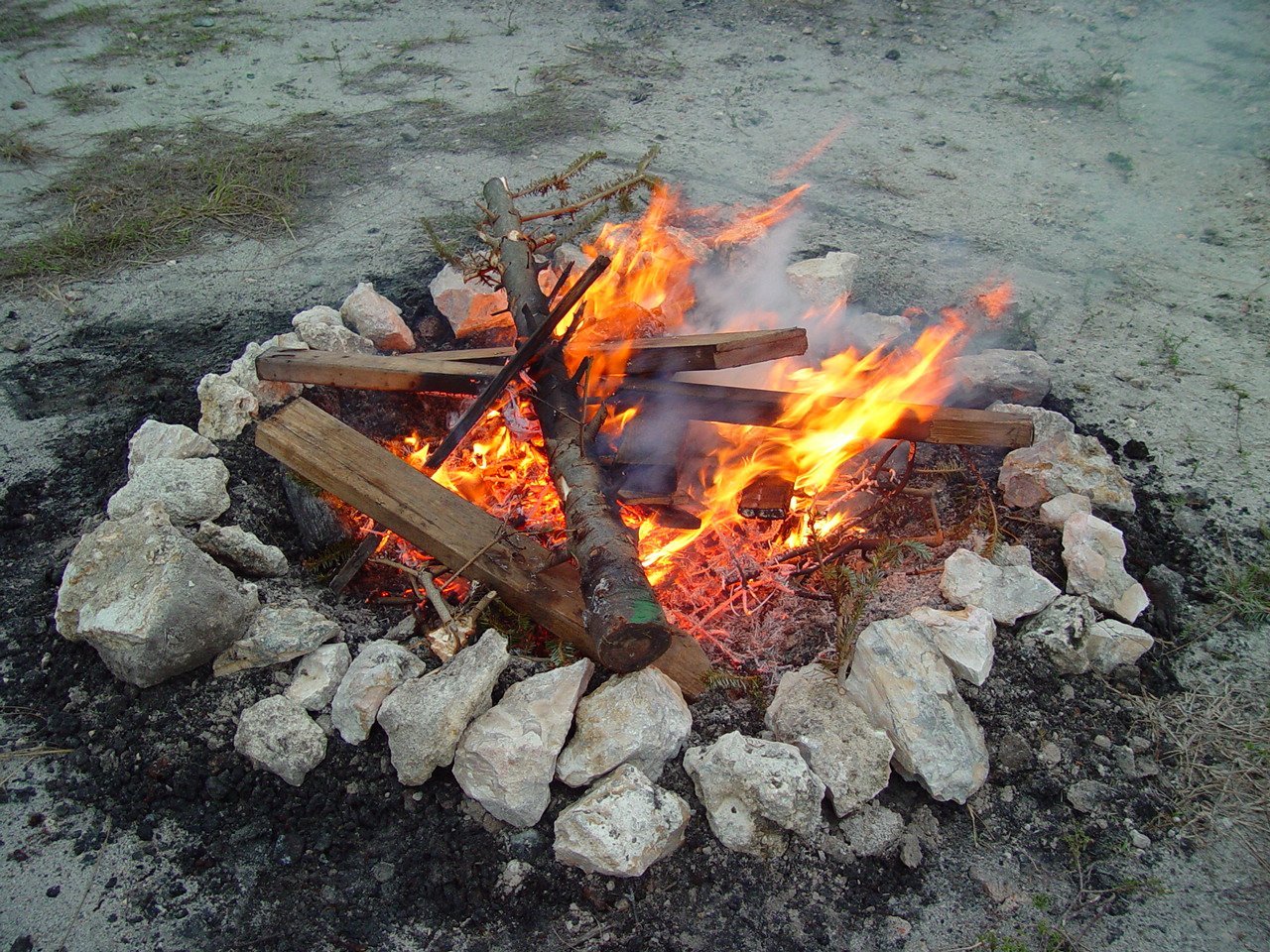Разведение открытого огня и использование. Костер обложенный камнями. Место для костра в лесу. Кострище с дровами. Разжигание костра.