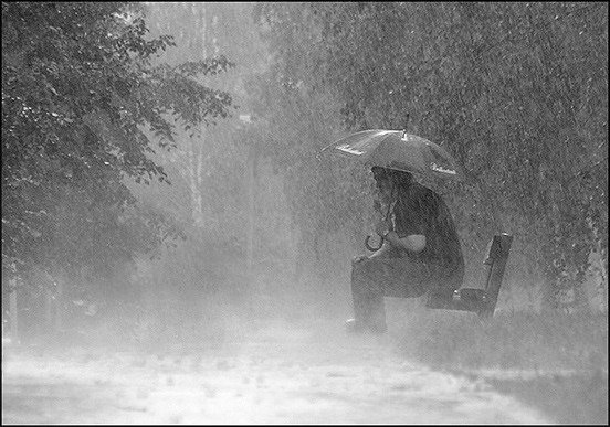 Парень на скамейке под дождем