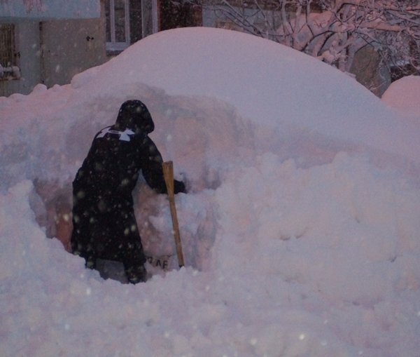 Разгребает снег