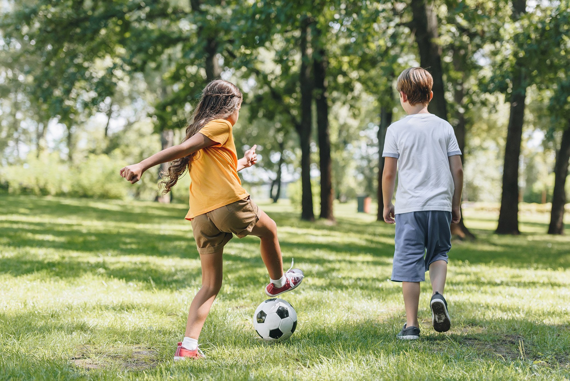 Играют в футбол в парке. Дети играют в мяч. Играющие дети в парке. Детский футбольный мяч в парке. Дети в парке с мячом.