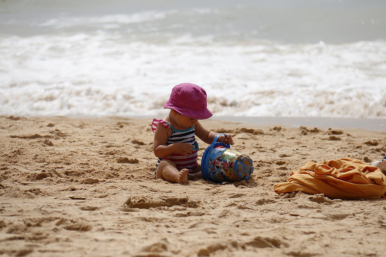 Две девочки, сидя на пляже и смотреть на море