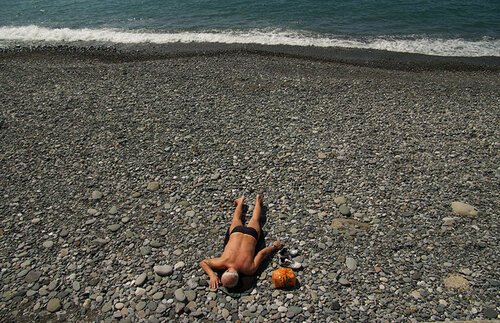 Загорает на гальке