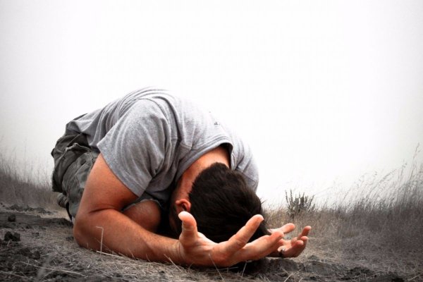 Мужчина молится на коленях