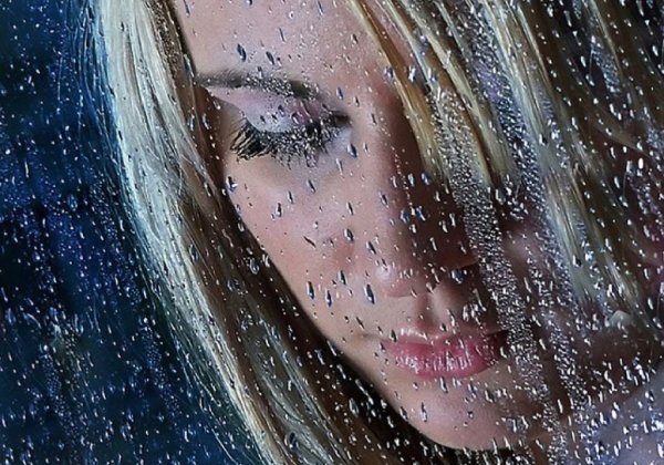 Девушка за стеклом плачет