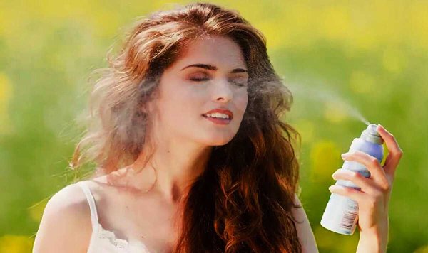 Девушка мажется солнцезащитным кремом