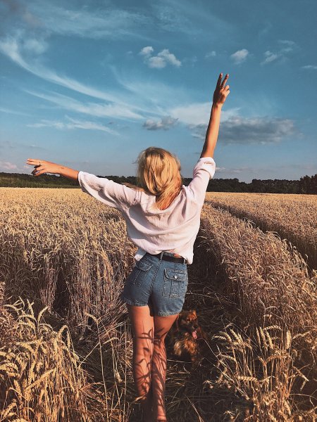 Девушка в поле со спины