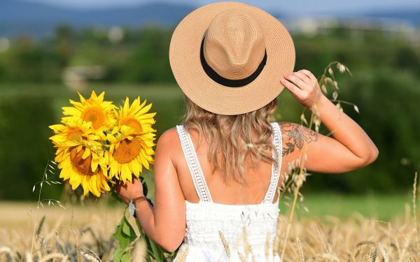 Девушка в поле цветов со спины