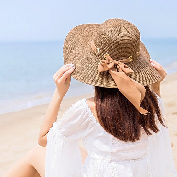 Девушка в платье и шляпе на берегу моря