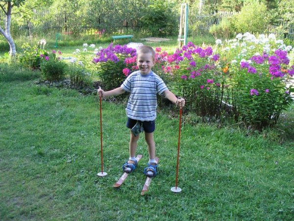 Летом мальчик катается на лыжах