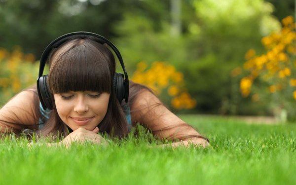 Девушка в наушниках на природе