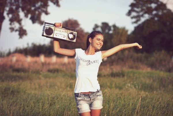 Девушка в наушниках танцует