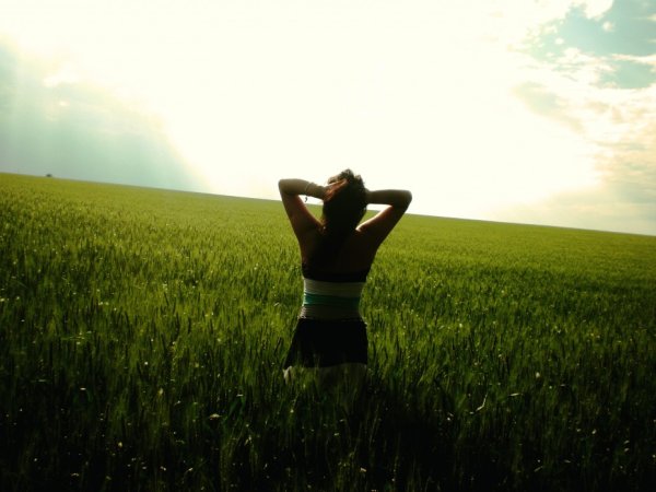 Девушка в поле со спины