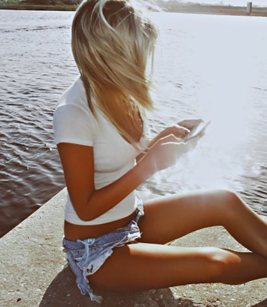 Блондинка в шортах на море