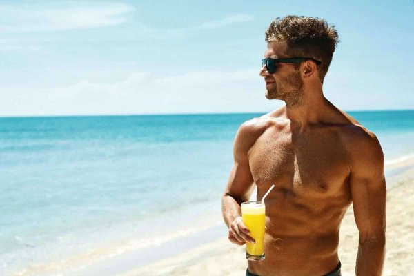 Мужчина на пляже с коктейлем