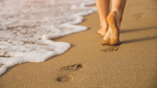 Следы ног на песке на море