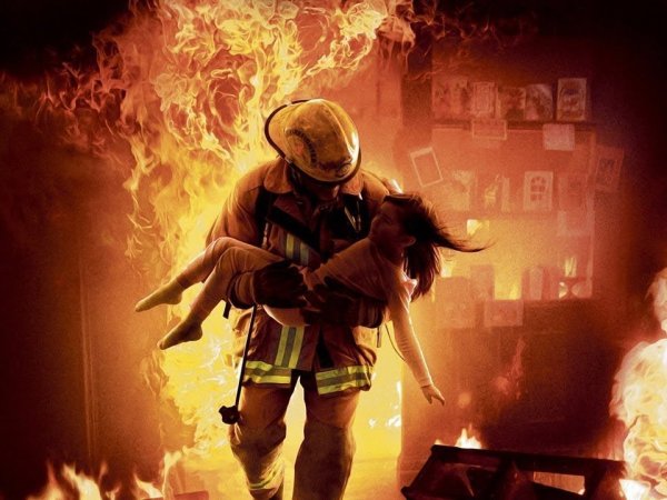 Пожарный выносит ребенка из огня