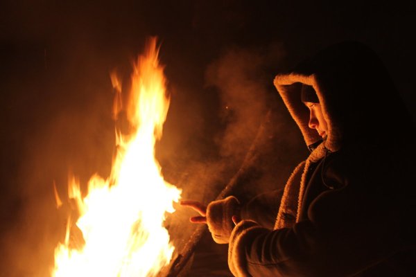 Люди греются у костра