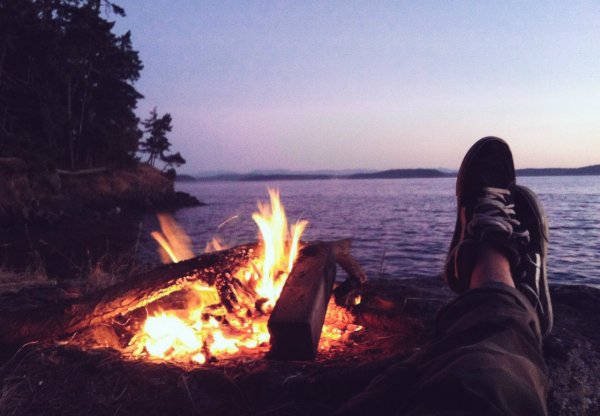 Девушка у костра спиной