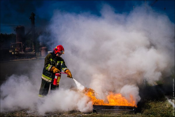 Пожарный тушит огонь