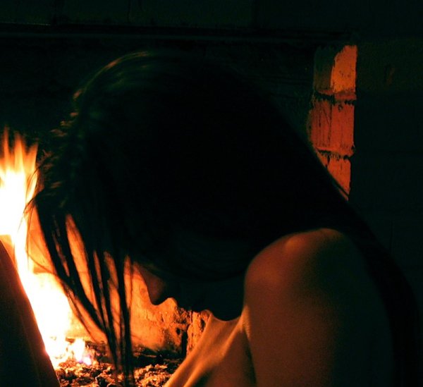 Девушка возле камина со спины