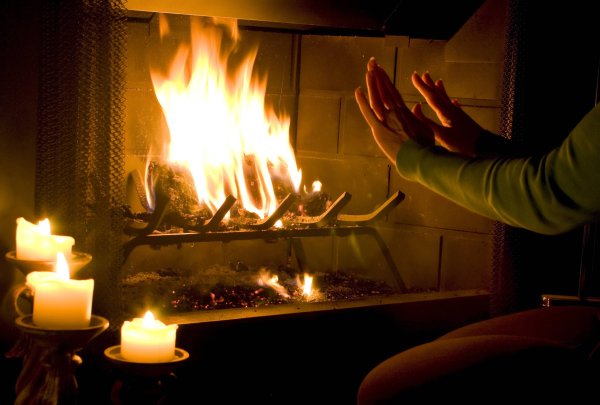 Человек греется у камина