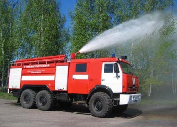 Пожарная машина и пожарные тушат