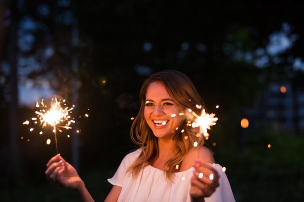 Девушка улыбается с бенгальскими огнями