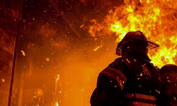 Пожарный на фоне пожара