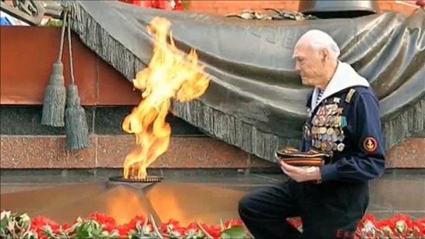 Ветеран на коленях у вечного огня