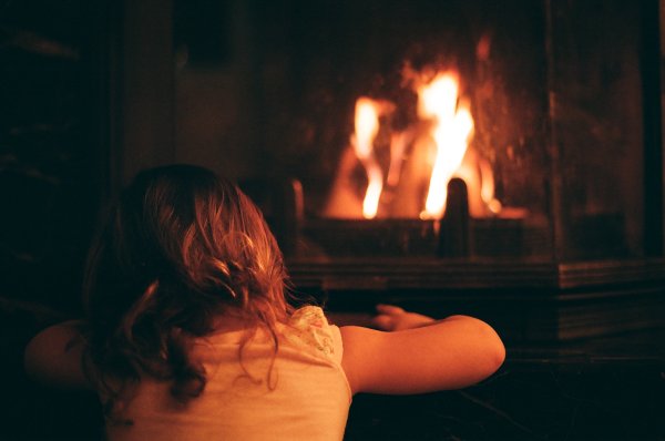 Девушка у камина со спины