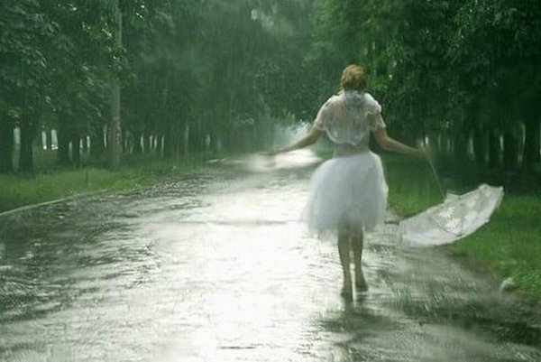 Девушка в платье бежит под дождем
