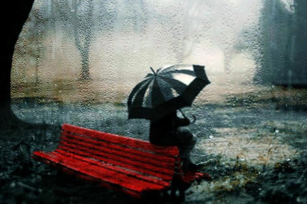 Человек на скамейке под дождем