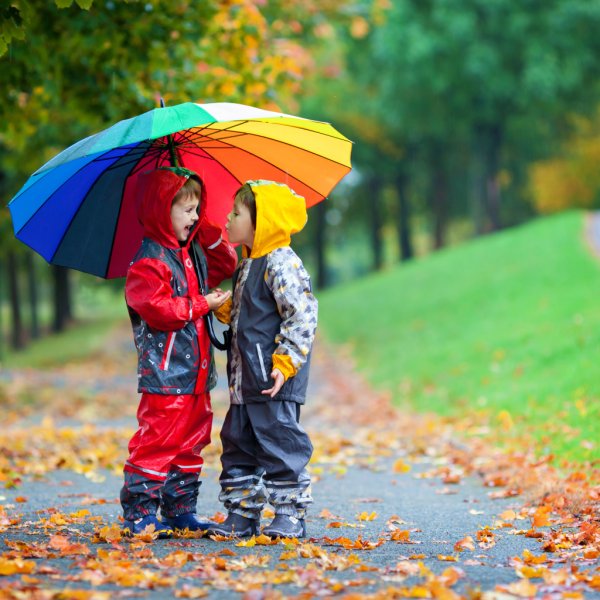 Дети одевают теплые одежды и с зонтиками фото