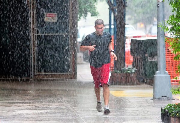 Человек бежит под дождем