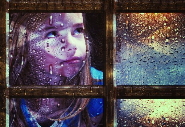 Отражение девушки в окне на фоне дождя
