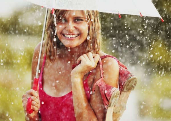 Счастливая девушка под дождем