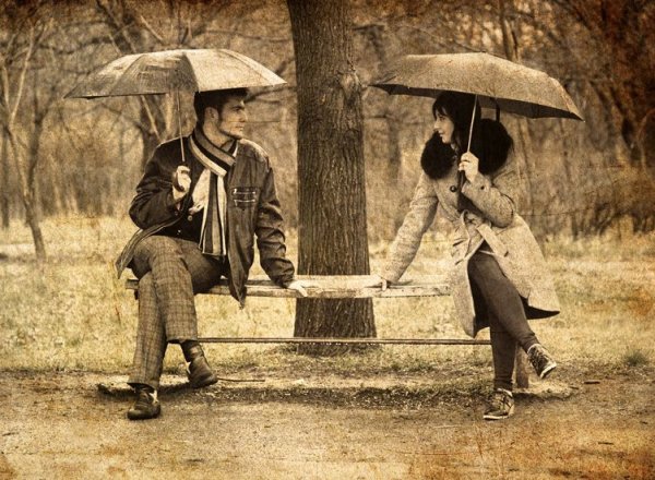 Мужчина с зонтом на скамейке