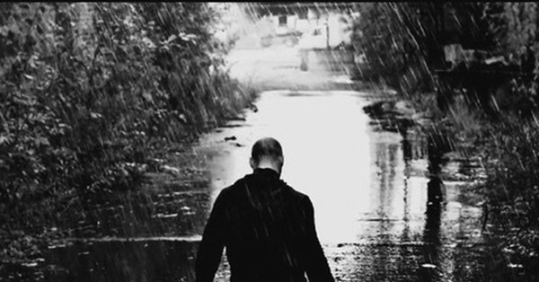 Парень сидит под дождем