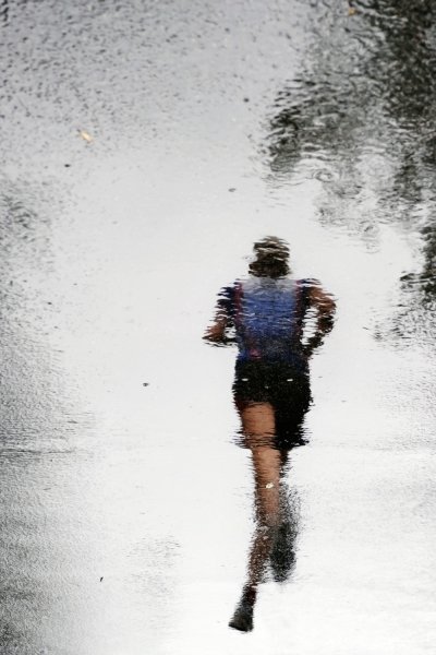 Человек бежит под дождем