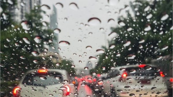 Raindrops on Road seen through car Window