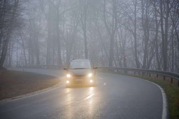 Машина на осенней дороге в тумане
