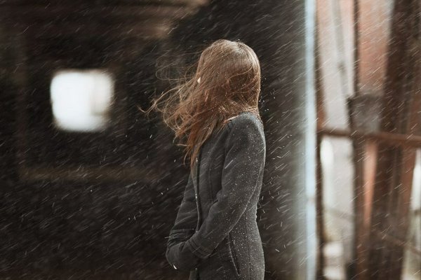 Женщина грустит у окна