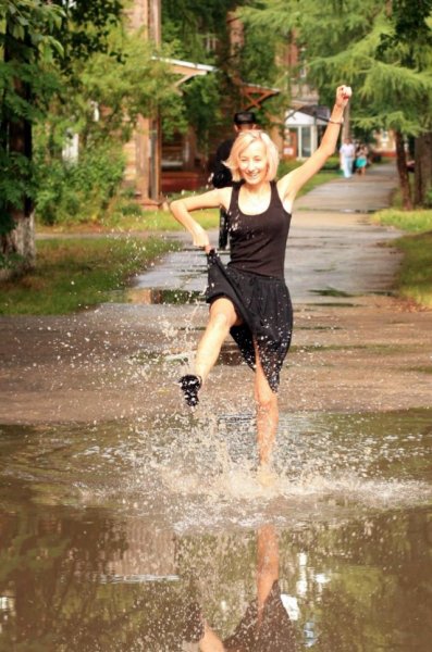 Девушка бежит по лужам