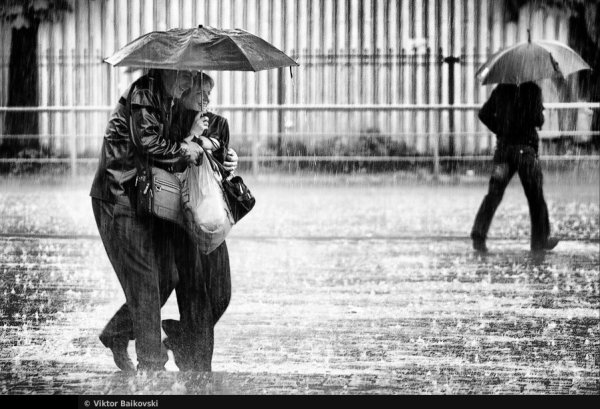 Мужчина с зонтом под дождем