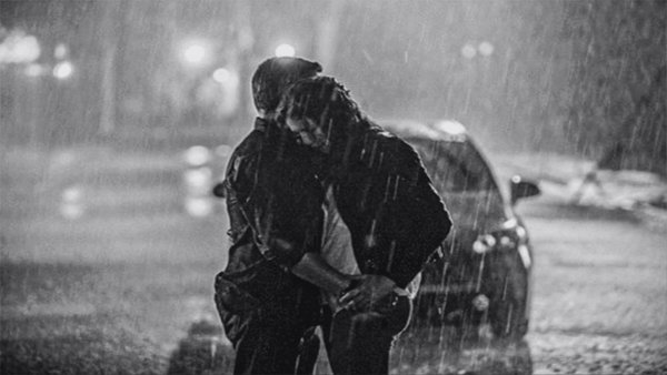 Парень и девушка обнимаются под дождем